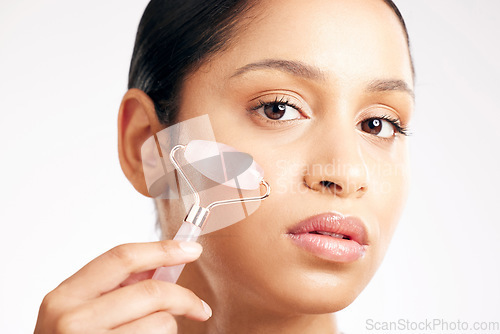 Image of Woman, portrait and face with derma roller in healthcare, skincare or dermatology against a white studio background. Female person or model rolling skin for beauty, self care or facial treatment