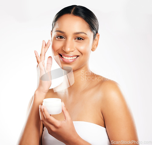 Image of Happy woman, portrait and face cream for skincare, beauty or cosmetics against a white studio background. Female person or model with product and smile for lotion, dermatology or facial treatment