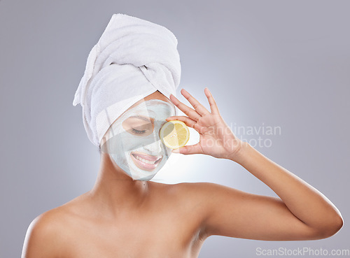 Image of Mask, skincare and lemon with woman in studio for beauty, natural cosmetics and vitamin c. Self care, glow and spa with face of female model and citrus fruit on grey background for detox product