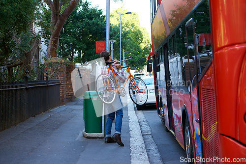 Image of En route to work. Shot of a man with his bicycle at a bus stop.