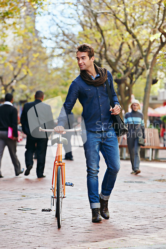 Image of Getting around the green way. Full length shot of a handsome man in the city with his bicycle.