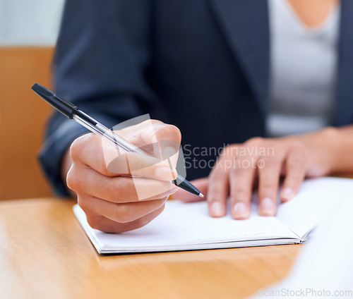 Image of Putting pen to paper...Closeup image of a businesswoman writing in a notebook.