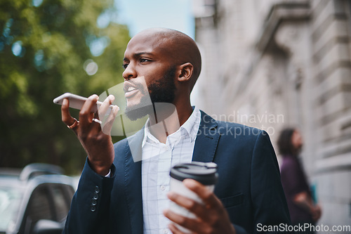 Image of Youre late for our coffee date. Shot of a businessman using his cellphone while out in the city.