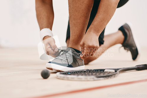 Image of Get set to get squashed. Cropped shot of a man tying his shoelaces before a game of squash.