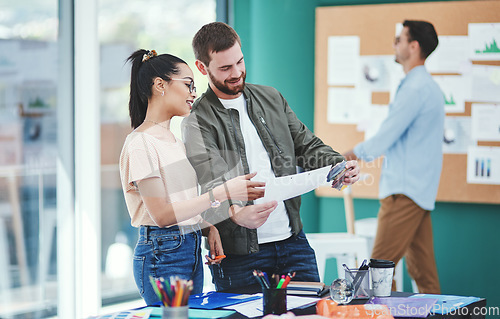 Image of Its about leaving a mark with their brand. Shot of two young designers having a discussion in an office.