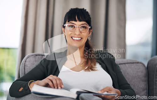 Image of Being at home is my favourite. Cropped portrait of an attractive young woman sitting alone in her living room and reading a book.