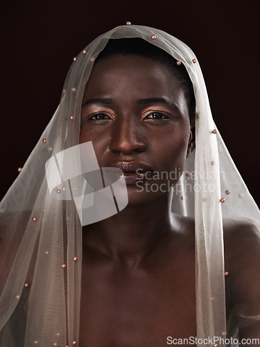 Image of Whatever youre facing, face it with confidence. Studio portrait of an attractive young woman posing in traditional African attire against a black background.