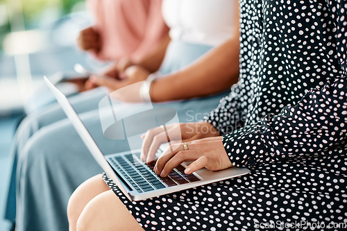 Image of Her notes will be safer digitally. Cropped shot of a group of unrecognizable businesswomen using wireless technology while sitting in line in a modern office.