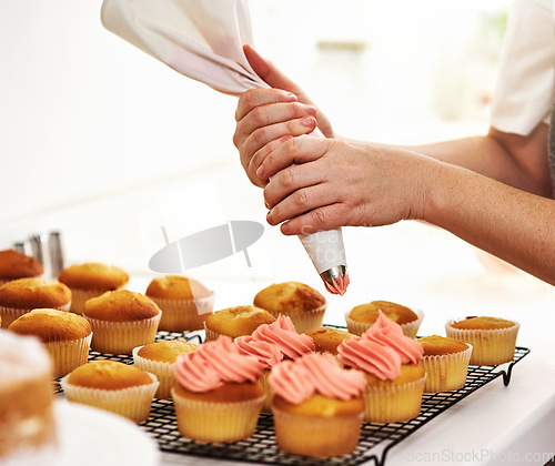 Image of Add a little magic. Cropped shot of an unrecognizable woman piping icing onto her cupcakes.