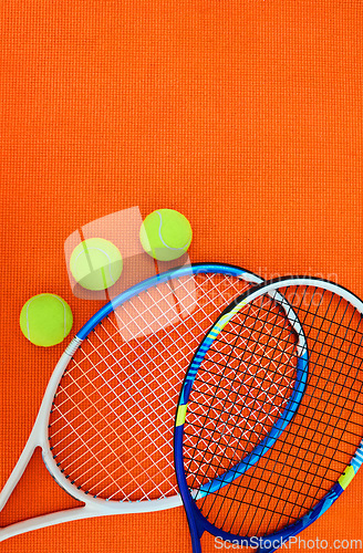 Image of Who wants to serve. High angle shot of tennis essentials placed on top of an orange background inside of a studio.