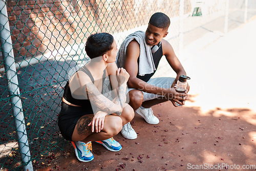 Image of They share so much in common. Shot of two sporty young people chatting to each other against a fence outdoors.