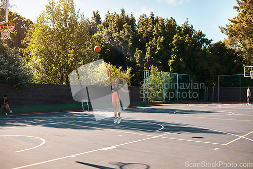 Image of Its not about how good you are, its how good you want to be. Shot of a sporty young woman throwing a basketball into a net on a sports court.