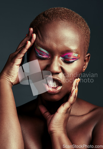 Image of Looking flawless in color. Cropped shot of a beautiful woman wearing colorful eyeshadow while posing against a grey background.