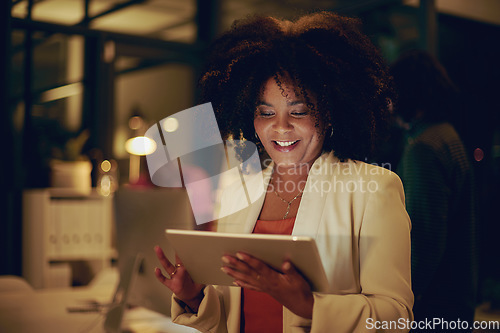 Image of This tool will help me reach deadline so much quicker. Shot of a businesswoman using a digital tablet in an office at night.