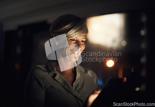 Image of I found an app thatll make my job easier tonight. Shot of a mature businesswoman using a digital tablet in an office at night.