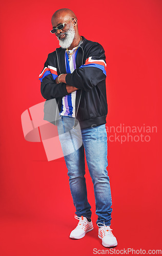 Image of Clothes never really go out of style. Studio shot of a senior man wearing retro attire while posing against a red background.