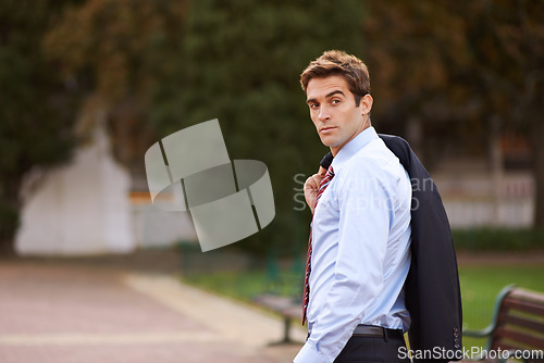 Image of Success follows wherever he goes. A handsome businessman walking outside with his jacket over his shoulder.