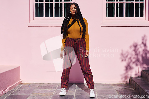 Image of She has style and a whole lotta attitude. Shot of a beautiful young woman posing against a pink wall.