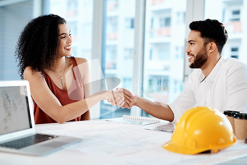 Image of I cant wait to see how it turns out. Cropped shot of two young businesspeople sitting together and shaking hands in agreement with building renovation plans.