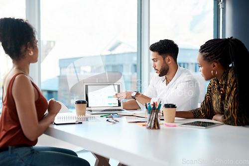 Image of We did very well as a company here. Cropped shot of a handsome young businessman using his laptop during a meeting with his female colleagues in the office.