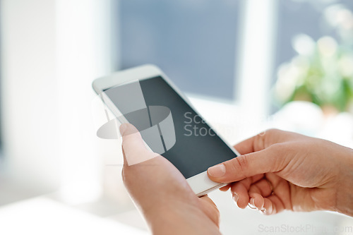 Image of Modern business requires modern technology. Cropped shot of an unrecognizable businesswoman using her smartphone inside of an office.