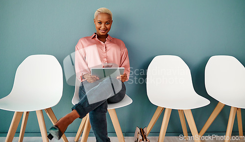 Image of Im ready to sweep this interview. Studio portrait of an attractive young businesswoman using a digital tablet while sitting in line against a grey background.