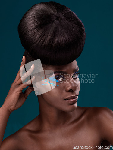 Image of Portrait, beauty and hair with an african woman in studio on a blue background for makeup or cosmetics. Face, haircare and fashion with an attractive young female model at the salon for trendy style