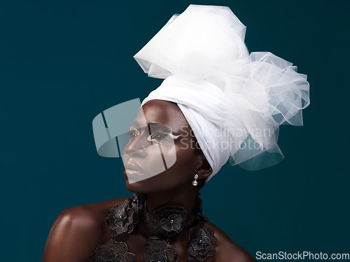 Image of 100 true beauty. Studio shot of an attractive young woman posing in traditional African attire against a blue background.