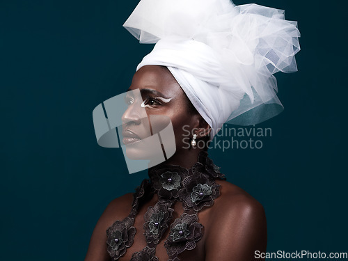 Image of Serving up some serious style inspiration. Studio shot of an attractive young woman posing in traditional African attire against a blue background.