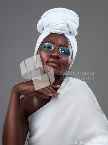 Image of Striking African beauty. Studio portrait of an attractive young woman posing in traditional African attire against a grey background.