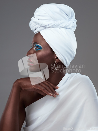 Image of The simplest accessories speak the loudest. Studio shot of an attractive young woman posing in traditional African attire against a grey background.