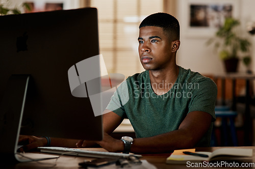 Image of Stay focused and watch the results come in. Shot of a young businessman using a computer in a modern office.