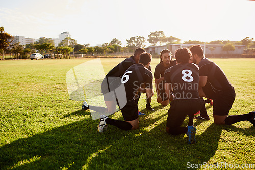 Image of We have to win. Full length shot of a diverse group of sportsmen crouching together before playing rugby during the day.