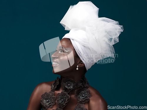 Image of Fashion is a silent language. Studio shot of an attractive young woman posing in traditional African attire against a blue background.