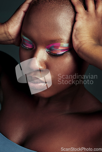 Image of Why fit in when you were born to stand out. Cropped shot of a beautiful woman wearing colorful eyeshadow while posing against a grey background.