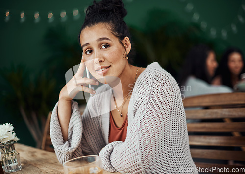 Image of What time will you be here. Shot of a beautiful young woman using a smartphone at a cafe.
