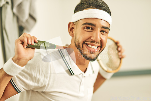 Image of Squash is my passion. Portrait of a happy young man holding his squash racket in the locker room.