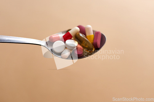 Image of When a diet turns into an eating disorder. Studio shot of medication served in a spoon against a brown background.