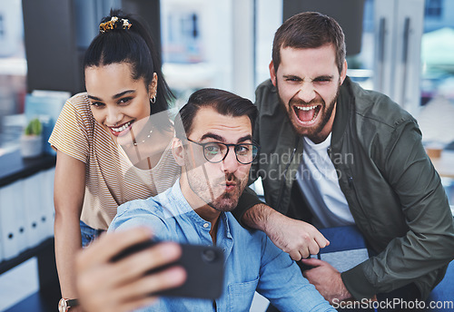 Image of Never a dull moment when this dynamic team are together. Shot of a group of designers taking selfies together in an office.