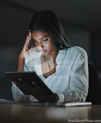 Image of This feels like a dead end. Shot of a young businesswoman looking stressed out while using a digital tablet in an office at night.