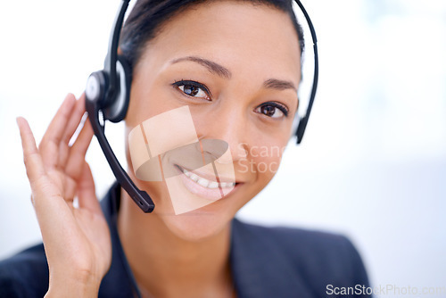 Image of Ready for any customer queries. Close up shot of an attractive female employee wearing headphones.