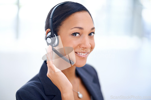 Image of Service with a smile. An attractive call centre operator smiling at the camera.