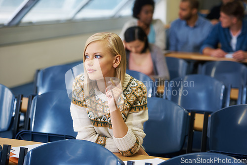 Image of The last exam before the real world begins. A group of students sitting in an exam room.