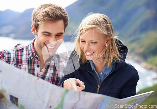 Image of Getting lost can actually be fun. A shot of a young couple studying a map on their road trip.