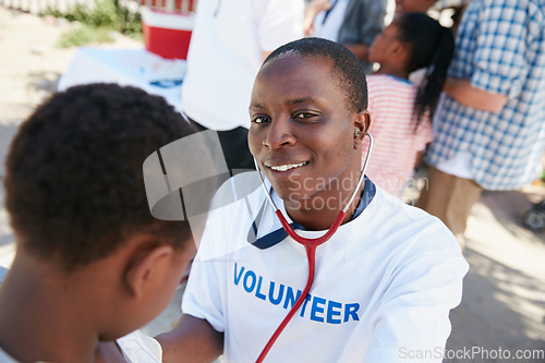 Image of On a mission to provide great medical care. Shot of a volunteer doctor examining a young patient with a stethoscope at a charity event.