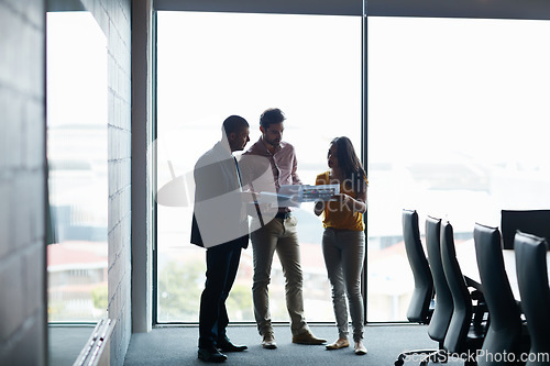 Image of Sorting themselves out before the meeting. Full length shot of three businesspeople talking in the boardroom.