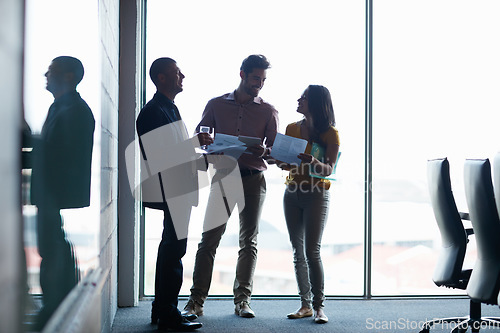 Image of Going over the briefing for the meeting. Full length shot of three businesspeople talking in the boardroom.