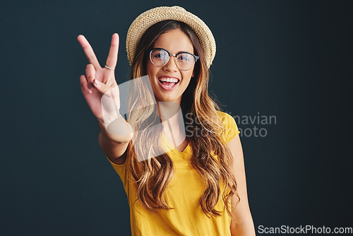 Image of Im all about peace and love. Studio shot of an attractive young woman against a dark background.