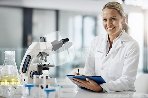 Image of Im here to cure. Cropped portrait of an attractive mature female scientist taking down notes while doing research in her lab.