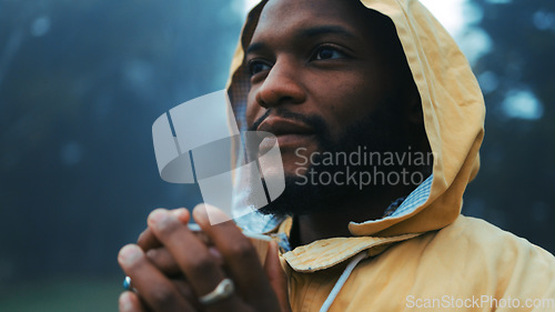 Image of Coffee, morning and a black man hiking in nature with a blurred background of cold, winter weather. Thinking, raincoat and face with a young male hiker in the woods or forest to explore for adventure